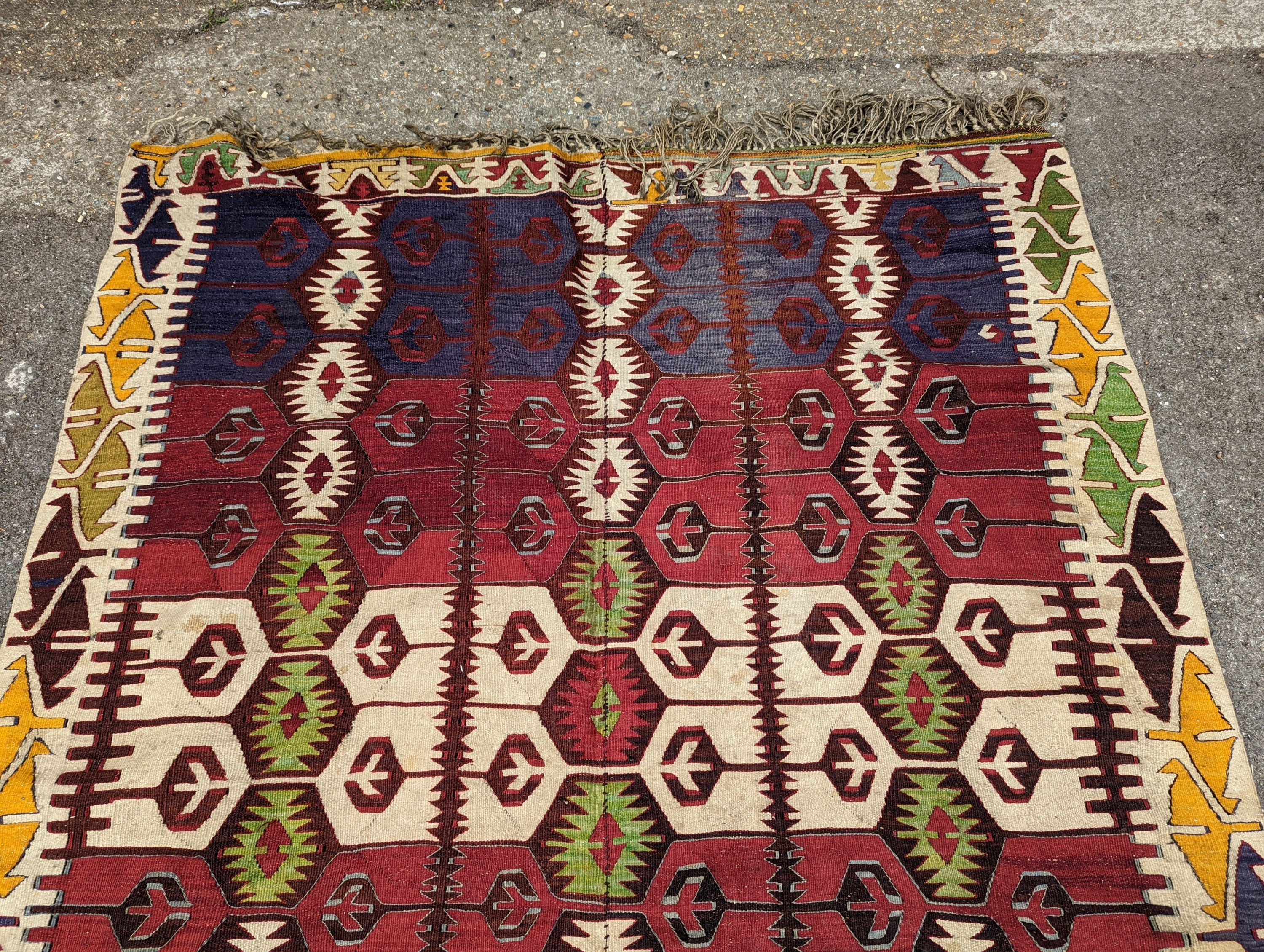 A Kelim polychrome flatweave carpet , cut centrally and re stitched, 425 x 163cm